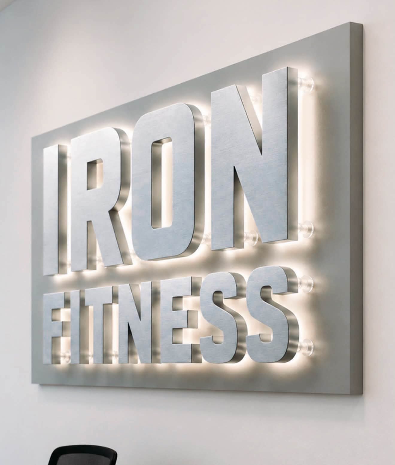 3D brushed stainless steel halo-lit letters mounted on standoffs for interior gym feature wall in Bugolobi, Kampala, Uganda.