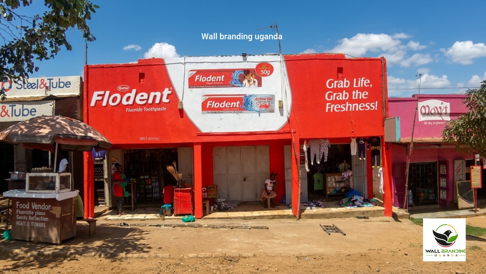Vibrant red commercial wall branding and painted advertisement for Flodent Toothpaste on a retail shop facade in Uganda.